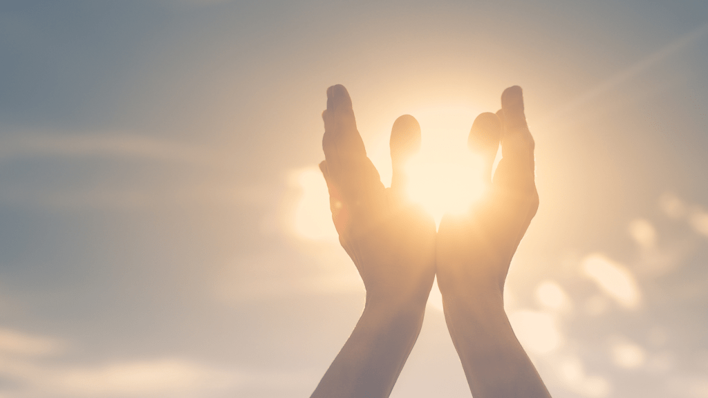 Image of hands looking like they're holding the sun due to perspective.